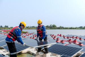 Male workers repair Floating solar panels on water lake. Engineers construct on site Floating solar panels at sun light. clean energy for future living. Industrial Renewable energy of green power. photo