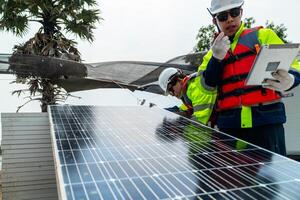 engineer men inspect modules of photovoltaic cell panels. Industrial Renewable energy of green power. workers prepare materials before construction on site with the stack of panels at background. photo