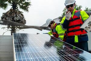 engineer men inspect modules of photovoltaic cell panels. Industrial Renewable energy of green power. workers prepare materials before construction on site with the stack of panels at background. photo