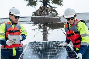 ingeniero hombres inspeccionar módulos de fotovoltaica célula paneles industrial renovable energía de verde fuerza. trabajadores preparar materiales antes de construcción en sitio con el apilar de paneles a antecedentes. foto