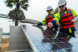 engineer men inspect modules of photovoltaic cell panels. Industrial Renewable energy of green power. workers prepare materials before construction on site with the stack of panels at background. photo