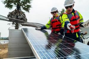 engineer men inspect modules of photovoltaic cell panels. Industrial Renewable energy of green power. workers prepare materials before construction on site with the stack of panels at background. photo