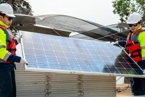 engineer men inspect modules of photovoltaic cell panels. Industrial Renewable energy of green power. workers prepare materials before construction on site with the stack of panels at background. photo