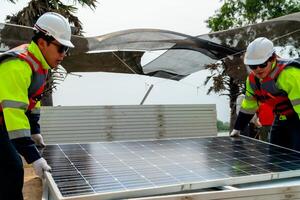 engineer men inspect modules of photovoltaic cell panels. Industrial Renewable energy of green power. workers prepare materials before construction on site with the stack of panels at background. photo