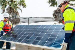 ingeniero hombres inspeccionar módulos de fotovoltaica célula paneles industrial renovable energía de verde fuerza. trabajadores preparar materiales antes de construcción en sitio con el apilar de paneles a antecedentes. foto