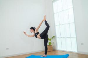 dos mujer confidente formación yoga. atlético mujer en ropa de deporte haciendo aptitud extensión ejercicios a hogar en el vivo habitación. deporte y recreación concepto. yoga profesor es Ayudar joven mujer. foto