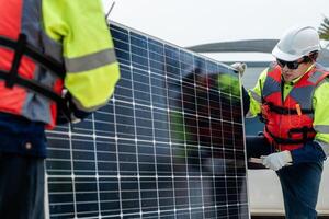 Workers Technicians are working to construct solar panels system on construction site. engineers are checking before Instal solar photovoltaic panel system. Renewable clean energy technology concept. photo