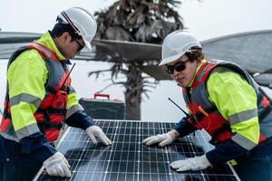 engineer men inspect modules of photovoltaic cell panels. Industrial Renewable energy of green power. workers prepare materials before construction on site with the stack of panels at background. photo