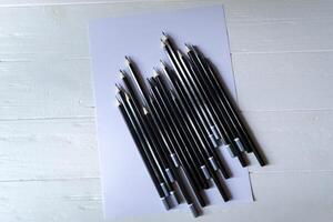 The set of grey pencils on a white background. Tools for drawing on the desk. photo