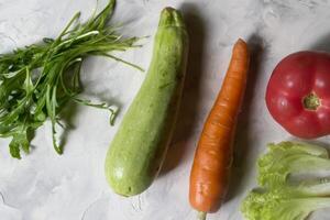 grupo de vegetales en un cocina mesa. ingredientes para Cocinando ensalada. foto