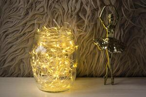 Ballerina statuette and jar with christmas lights. Home decorations. photo