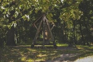 An old wooden pavilion in the forest. Peaceful place for relaxation. photo