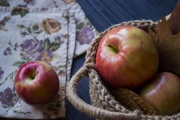 Red apples in a basket on a table.