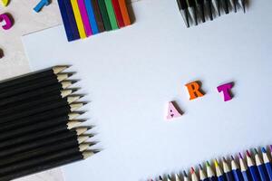 Multicolor letters and set of pencils on the table. Colorful wooden alphabet and pencils on a table. photo