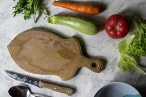 ingredientes para Cocinando ensalada, y cuchillería en un cocina mesa. foto