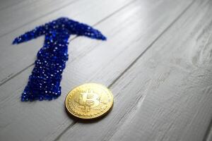 dorado bitcoin y azul flecha en un blanco antecedentes. foto