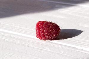 Ripe raspberries on a white wooden background. photo