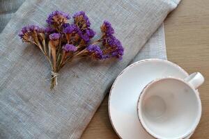 Empty coffee cup and kitchen textile on a table. photo