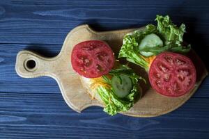 The sandwiches with vegetables on a board. Vegetarian food. Ingredients for cooking on the table. photo