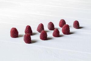 Ripe raspberries on a white wooden background. photo