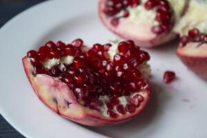 Pomegranate on a white plate. Close up. photo