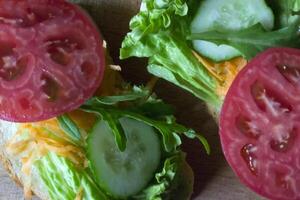 el emparedados con vegetales en un tablero. vegetariano alimento. ingredientes para Cocinando en el mesa. foto