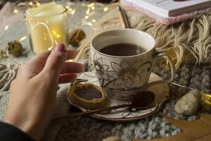 Woman's hand near a cup of coffee. Relax atmosphere at home. photo