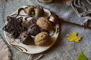 A cup of tea and sweet snacks with decoration by autumn leaves on the warm plaid. Seasonal still life. photo