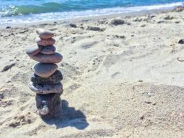 A group of sea stones on the sand near sea. photo