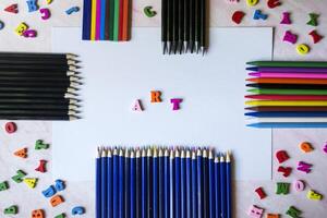 Multicolor letters and set of pencils on the table. Colorful wooden alphabet and pencils on a table. photo