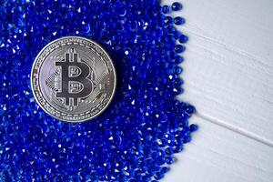 Silver bitcoin on a blue rhinestones. photo