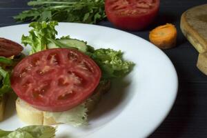 The sandwiches with vegetables on the plate. Vegetarian food. Ingredients for cooking on the table. photo