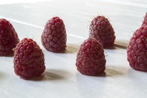 Ripe raspberries on a white wooden background. photo