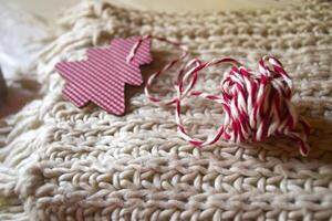 Christmas decorations on the knitted plaid. A toy in a form of christmas tree. photo