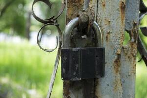 Old padlock on a rusty fence close up. photo