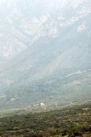 A mountain with a cargo truck on the road photo