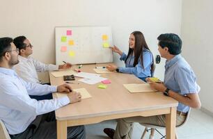 un grupo de personas sentado alrededor un mesa foto