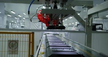 A robotic arm stacks computer monitors on a conveyor belt. A large workshop for the production of electronic components. video