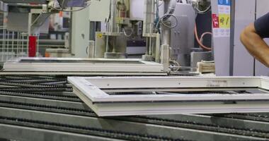 The operator works on a robotic conveyor for the production of plastic windows video