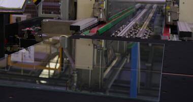 The operator works on the conveyor for glass processing. Large workshop video