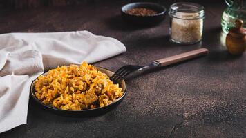 delicioso asiático pilaf con carne en un plato en el mesa web bandera foto