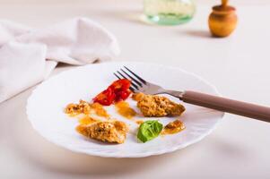 Stop food waste. Leftover food on a plate after dinner on the table. photo