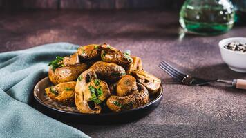 Sliced grilled mushrooms with herbs on a plate on the table web banner photo