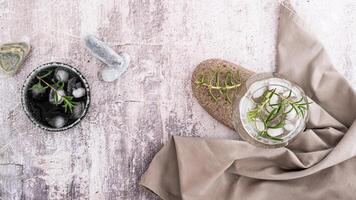 Glass with carbonated alcoholic drink with rosemary and ice in glass on table top view web banner photo