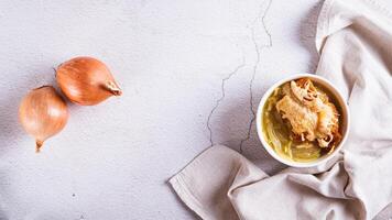 French onion soup with baked cheese bread in a bowl on the table top view web banner photo