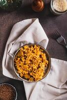 Traditional spicy pilaf with rice and meat on a plate on the table top and vertical view photo