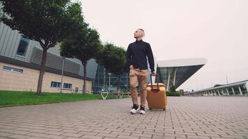 mannetje zakenman terugkeren van een bedrijf reis. een Mens wandelingen Holding bagage in zijn hand. video