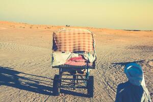 Beduins leading tourists on camels at short tourist tour around the beginning so called Doors of Sahara desert photo