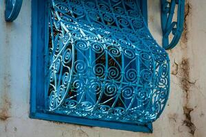 Beautiful ornamental blue windows on a white wall so typical for Tunisia photo