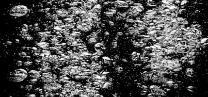 Soda water bubbles splashing underwater against black background. photo